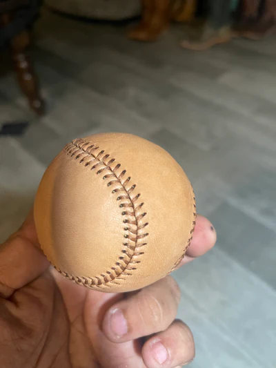 Tan leather baseball in hand